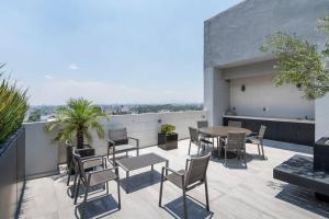 eine Terrasse mit einem Tisch und Stühlen auf dem Dach in der Unterkunft Lovely 3-bedroom with pool in La Roma Norte in Mexiko-Stadt