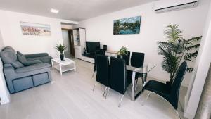 a living room with a couch and a table and chairs at apartaluxdenia in Denia