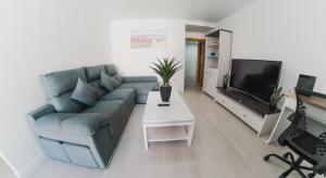 a living room with a couch and a tv at apartaluxdenia in Denia