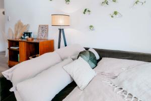 a couch with white pillows in a living room at Grüne Wohnoase - stilvoll - Balkonidylle - Zentrum in Neuwied