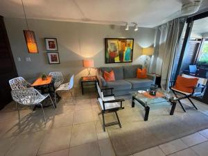 sala de estar con sofá, mesa y sillas en Sapphire del Mar B-106 Ocean Front Beach Level, en Nazareth