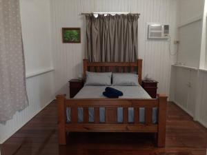 a wooden bed in a room with a window at Wangan Tropical Getaway 