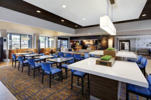 a dining room with tables and blue chairs at Courtyard Atlanta Marietta/I-75 North in Marietta