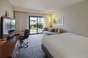 a hotel room with a bed and a desk with a television at Courtyard Atlanta Marietta/I-75 North in Marietta