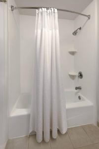 baño con cortina de ducha blanca y bañera en Courtyard Atlanta Marietta/I-75 North en Marietta