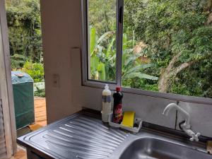 um lavatório numa cozinha com uma janela e um lavatório em Casa de Praia Ubatuba em Ubatuba