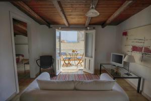 a living room with a white couch and a television at Alla Giudecca in Syracuse