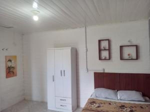Hospedaria Mirante da Maré ap8 في إيمبيتوبا: غرفة نوم مع سرير وخزانة بيضاء