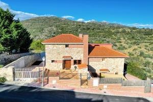 ein Haus mit einem Berg im Hintergrund in der Unterkunft Luxe Villa, Pool, Mountain views, BBQ, Sky, in Miraflores de la Sierra