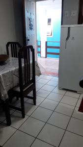 uma cozinha com uma mesa, 2 cadeiras e um frigorífico em Golden Dolphin Residence em Taperapuan perto Axé Moi em Porto Seguro