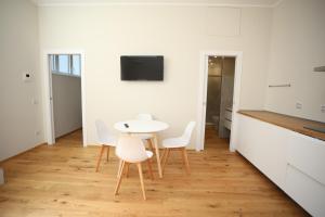 a white kitchen with a white table and chairs at Cozy Loft in charme position - Brera Moscova in Milan