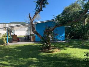 uma casa azul com uma árvore no quintal em Refúgio Andrade em Governador Celso Ramos