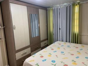 um quarto com uma cama, um espelho e cortinas em Refúgio Andrade em Governador Celso Ramos
