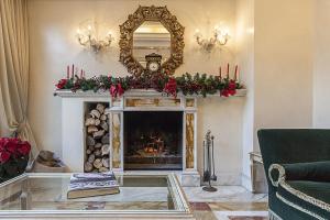 a living room with a fireplace with a mirror at Trilussa Palace Hotel Congress & Spa in Rome