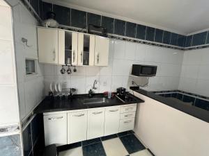 a kitchen with white cabinets and a sink at Albuquerque nro36 casa 3 in Campinas +3 photos