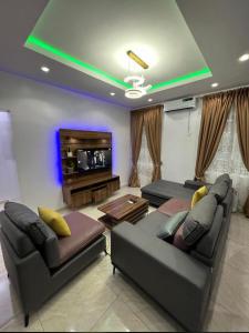 a living room with two couches and a flat screen tv at Melford Homes in Lagos