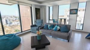 a living room with a couch and chairs and windows at Departamento vista al mar en Manta Poseidon in Manta
