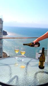 a person pouring wine into two wine glasses on a table at Departamento vista al mar en Manta Poseidon in Manta