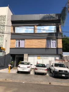 a building with cars parked in a parking lot at Hotel Matamoros in Tepatitlán de Morelos