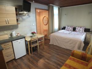 a bedroom with a bed and a table and a kitchen at Villa Žvejų 29 in Palanga