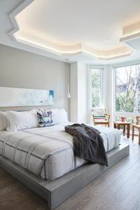 a white bedroom with a large bed in a room at Elegant Downtown Home in Toronto