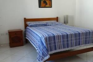 a bedroom with a blue and white bed and a night stand at Excelente casa em condomínio fechado em Juquehy. 2 suítes, ar, piscina comum. in São Sebastião +41 photos