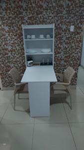 uma mesa branca e duas cadeiras num quarto em Apê Aconchegante no Recife