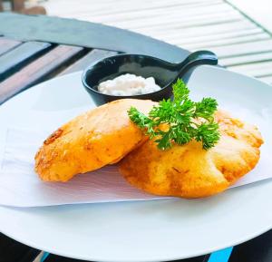 um prato branco com dois alimentos com um molho em Hotel Isabella Tayrona em Los Naranjos