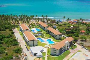 eine Luftaufnahme eines Resorts in der Nähe des Ozeans in der Unterkunft Bangalô Design Carneiros Beach Resort com serviço in Tamandaré