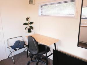 an office with a desk and a chair and a window at Delightful Lake Hawea Cabin with Mountain Views in Lake Hawea