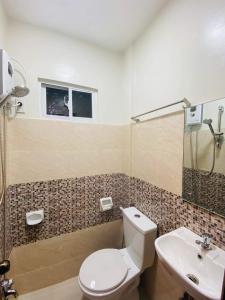 a bathroom with a toilet and a sink at Mongki's Pensionhouse in Puerto Princesa City