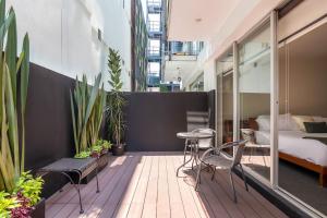 a balcony with a bed and a table and chairs at Chic 2BR Condo in Condesa steps from Parque Mexico in Mexico City