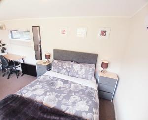 a bedroom with a bed and a desk with two lamps at Delightful Lake Hawea Cabin with Mountain Views in Lake Hawea
