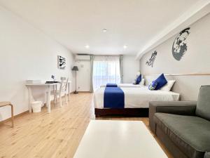 a bedroom with a bed and a couch and a table at Hotel Miyakojima in Miyako Island