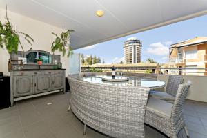 a patio with a table and chairs on a balcony at Belle Escapes - Beach Retreat Townhouse Glenelg in Glenelg
