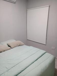 Cama en habitación con espejo en la pared en Departamento completo en Resistencia