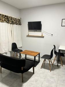 sala de estar con TV, mesa y sillas en Departamento completo en Resistencia