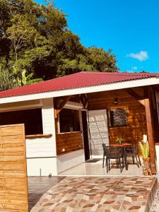 a house with a patio with a table and chairs at Honey House in Rivière-Pilote +8 photos