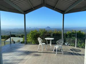 a patio with a table and chairs and a view at Tranquil Park in Maleny