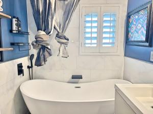 a white bathroom with a tub and a window at Pick from Curated Vintage Vinyl 3B-2B Lic 65597 in La Quinta