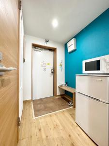 a small kitchen with a refrigerator and a microwave at Hotel Miyakojima in Miyako Island