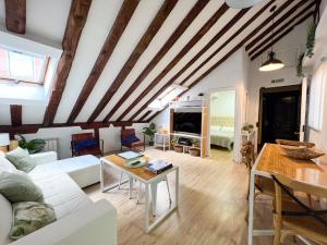 un salon avec un canapé blanc et une table dans l'établissement Callao Suites, à Madrid