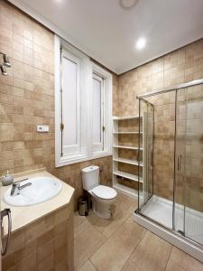 une salle de bains avec toilettes, lavabo et douche dans l'établissement Callao Suites, à Madrid 180 autres photos