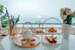 a table with two plates of food and a tea pot at Nj homestay in Ban Thung Phan Ha