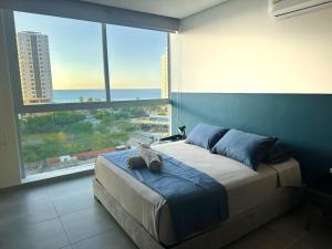 a bedroom with a bed with a cat laying on it at Salguero Suites - Playa Salguero - By INMOBILIARIA VS in Santa Marta