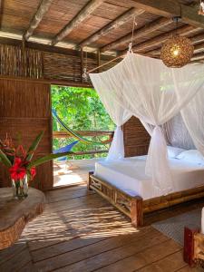 1 dormitorio con 1 cama con mosquitera en La Martina Ecolodge, en Nuquí