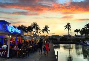 a group of people sitting at a restaurant next to a pond at Le Mik-Appartement in Le Gosier +15 photos