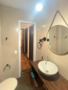 y baño con lavabo, aseo y espejo. en Apartamento 4 quartos 500m Arpoador, en Río de Janeiro