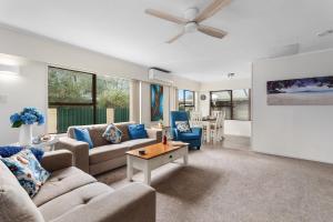 sala de estar con 2 sofás y ventilador de techo en A Stones Throw - Coastlands Holiday Home, en Whakatane