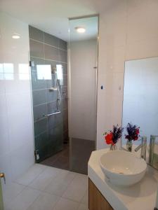 W łazience znajduje się umywalka i przeszklony prysznic. w obiekcie Comfy+ by ARH KLCC w Kuala Lumpur